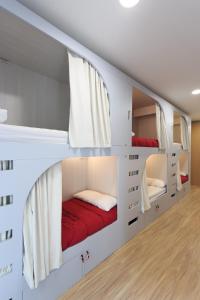 潘普洛纳奥博古潘普罗那依鲁纳考酒店的一间设有白色双层床和红色床单的客房