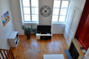 里昂本园公寓的客厅配有电视和墙上的时钟