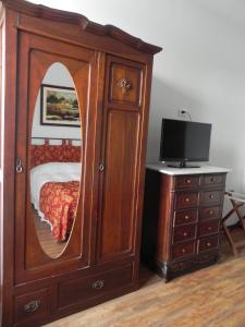 科洛尼亚-德尔萨克拉门托贝尔特兰酒店的一间卧室配有带镜子的大型木制橱柜