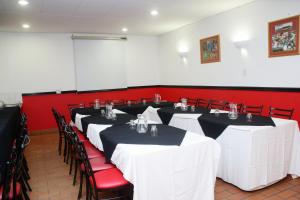 德班里维埃拉德班酒店的红色墙壁的房间的一排桌子