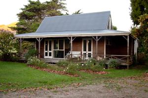 WairoaThe Cottage的院子中一座金属屋顶的小房子