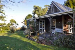 WairoaThe Cottage的一个小房子,设有门廊和院子