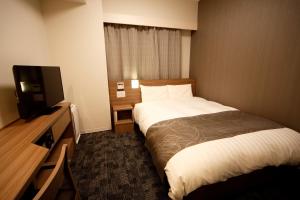 长野多美迎长野酒店的配有一张床和一台平面电视的酒店客房