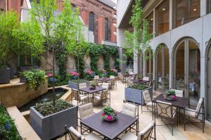 费城里滕豪斯酒店的户外庭院配有桌椅和树木。