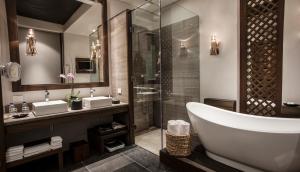 坎昆尼祖克度假及Spa酒店的带浴缸、两个盥洗盆和淋浴的浴室。