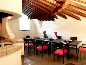 卡塞勒托瑞尼斯杰特酒店的一间用餐室,配有黑桌子和红色椅子