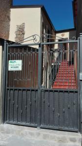 Prignano CilentoB&B Il Giardino sull'Alento的大楼前有红色座椅的黑色门