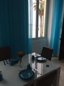 因佩里亚Casa al Prino的一张带蓝色盘子的桌子,享有海滩美景