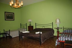 Torre le NocelleAgriturismo Casale 1921的绿色卧室配有两张床和吊灯