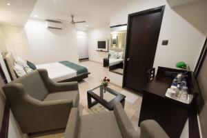 孟买Hotel Le Grande - Mumbai International Airport的酒店客房设有床和客厅。