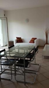 加尔达湖滨Riva Apartment Negrelli的客房内的玻璃桌、椅子和沙发