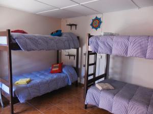 圣佩德罗·德·阿塔卡马坎普基地旅舍的一间房间,设有三张双层床