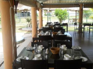蒙舒瓦西毛里求斯舒瓦西旅馆的餐厅设有黑桌椅和大窗户