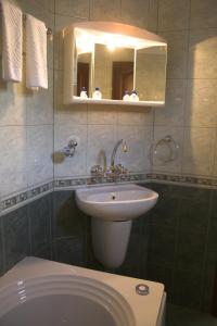 阿塞诺夫格勒老时光酒店的一间带水槽、卫生间和镜子的浴室