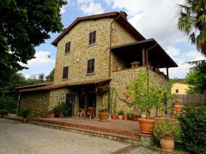 Terontola卡萨迪娜住宿加早餐旅馆的一座古老的石头房子,前面设有一个庭院