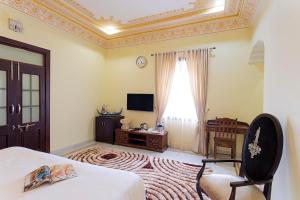克久拉霍瑟纳赫里蒂奇酒店的一间卧室设有一张床、一台电视和一个窗口。