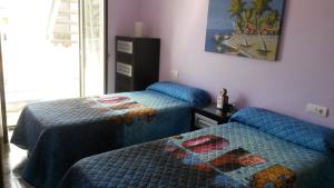 多列毛利诺斯Apartamento Puerto Real的卧室配有两张床,墙上挂着一幅画