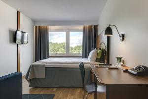 布罗斯布罗斯格兰德品质酒店的配有一张床、一张书桌和一扇窗户的酒店客房