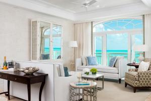 格雷斯湾特克斯和凯科斯群岛海岸俱乐部度假村的客厅配有白色家具,享有海景。