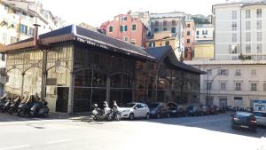 热那亚Il Riposo del Guerriero Guesthouse的一条城市街道上的一座建筑,里面装有摩托车和汽车