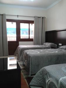 纳祖尔Hotel Mediterranee的酒店客房设有两张床和窗户。