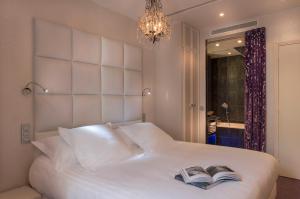 巴黎格拉莫尔别墅酒店的卧室配有白色的床,上面有两本书