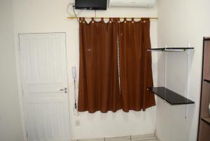 坎皮纳斯Lize Hotel Rodoviária的一间设有棕色窗帘和门的房间