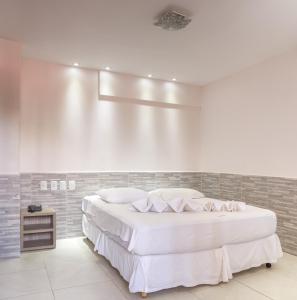 若昂佩索阿波萨达亚特兰帝卡酒店的白色卧室配有一张白色的大床