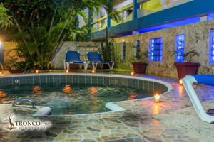 博卡奇卡Hotel El Tronco Inc的一座带蓝色椅子和灯光的游泳池