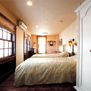 南鱼沼市米斯特拉尔宾馆的一间卧室设有两张床和窗户。