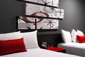 帕萨迪纳帕萨迪纳阿斯特罗酒店的客房配有两张带红白色枕头的床。