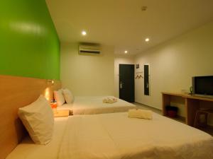玻璃市港口玻璃市瓜拉T酒店的酒店客房设有两张床和绿色的墙壁。