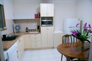 库伯佩迪凯夫普雷斯公寓的厨房配有桌子和白色冰箱。