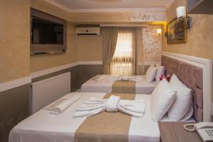 伊斯坦布尔贝斯特酒店的两张位于酒店客房的床,配有毛巾