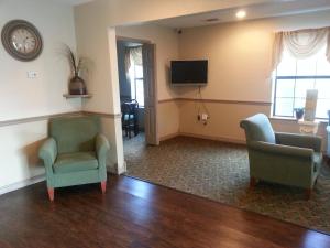 毛米勒美国最佳价值酒店及套房 - 小石城 - 茂美勒的客厅配有两把椅子和电视