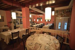 伊瓜苏港波萨达索根特酒店的用餐室配有桌椅和白色桌子