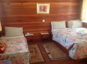 波特尔堡Bwigamiro Country Home Fort Portal的木墙客房的两张床
