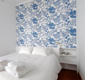 科尔多瓦拉霍格拉公寓的一间卧室配有一张蓝色和白色壁纸的床