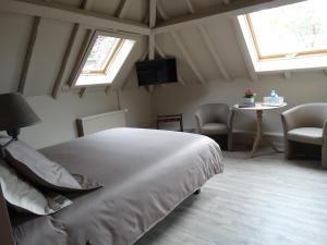 RuiseledeB&B Castel 't Haantje的一间卧室设有床、两个窗户和一张桌子