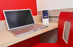 托尔西普瑞米尔玛娜瓦雷托西经典酒店的一张桌子上的笔记本电脑和红色椅子