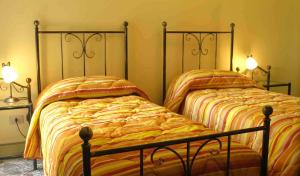 菲乌梅夫雷多迪西奇利亚太阳的色彩住宿加早餐旅馆的卧室内两张并排的床