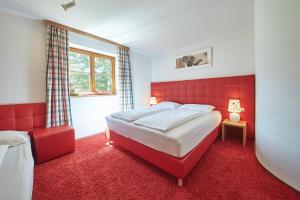 萨尔巴赫Holiday Lodge Felix的红色卧室设有一张大床和一个窗户