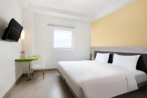 马卡萨佩塔拉尼爱玛瑞丝酒店 - 望加锡的白色卧室配有床和桌子