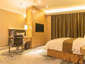 中山中山盛景尚峰酒店的酒店客房配有一张床、一张书桌和一台电视。