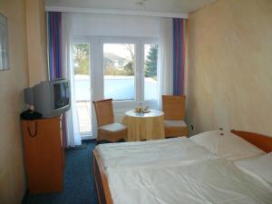 库克斯港诺德思特维餐厅酒店的一间卧室配有一张床、一台电视和一张桌子