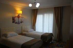 MutDeveci Hotel的酒店客房设有两张床和窗户。