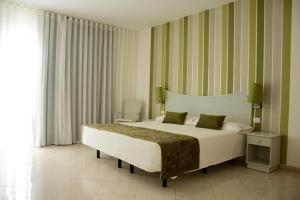 圣玛丽亚Ouril Pontao Hotel的一间卧室设有一张大床和大窗户