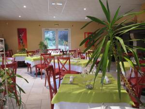 Saint-Pantaléon-de-Larche科伦姆比酒店的一间设有桌椅和盆栽的餐厅