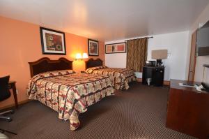 威廉斯敦威廉斯敦汽车旅馆的酒店客房设有两张床和一张桌子。