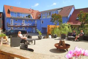 勒伯尔Ferienwohnungen Malow的一群人坐在一个蓝色建筑的庭院里